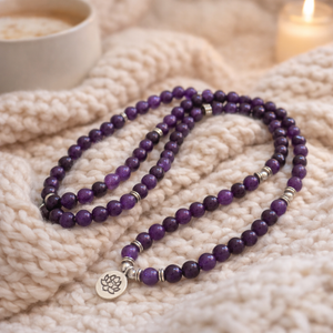 mâlâ de 108 perles améthyste posé sur un plaid