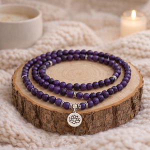 mâlâ de 108 perles améthyste posé sur rondin de bois