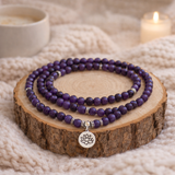 mâlâ de 108 perles améthyste posé sur rondin de bois